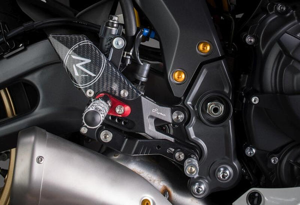 LighTech FTRYA018R R-version rearsets installed on Yamaha R7, brake-side close-up; optional red footpeg holders and other motorcycle accessories shown are not standard kit contents.