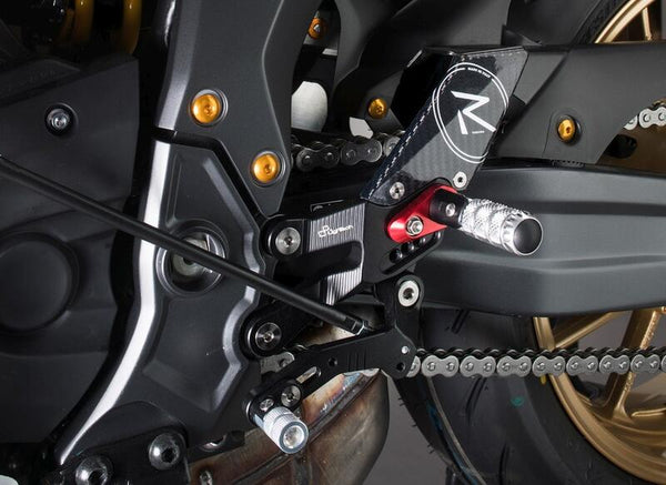 LighTech FTRYA018R R-version rearsets installed on Yamaha R7, shift-side close-up; optional red footpeg holders and other motorcycle accessories shown are not standard kit contents.