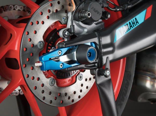 LighTech TEYA010COB chain adjuster installed, brake-side view; axle sliders, axle nuts, stand lifters, motorcycle and other accessories shown are not included.