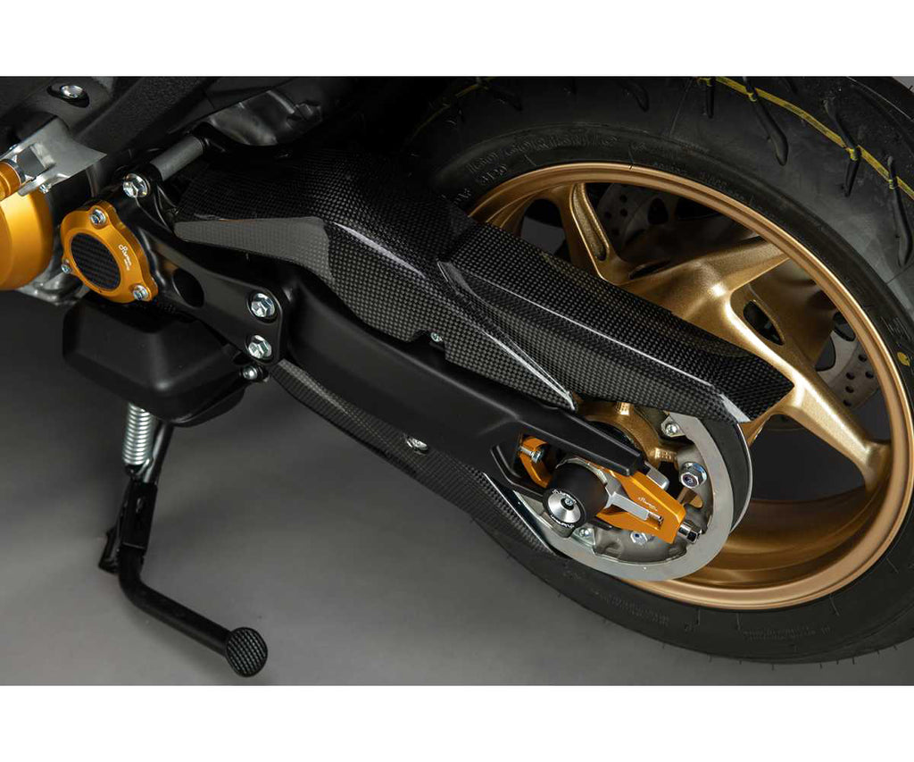 LighTech CARY4912 gloss carbon fibre upper belt cover installed on Yamaha TMAX; upper cover only, lower cover and gold accessories not included.