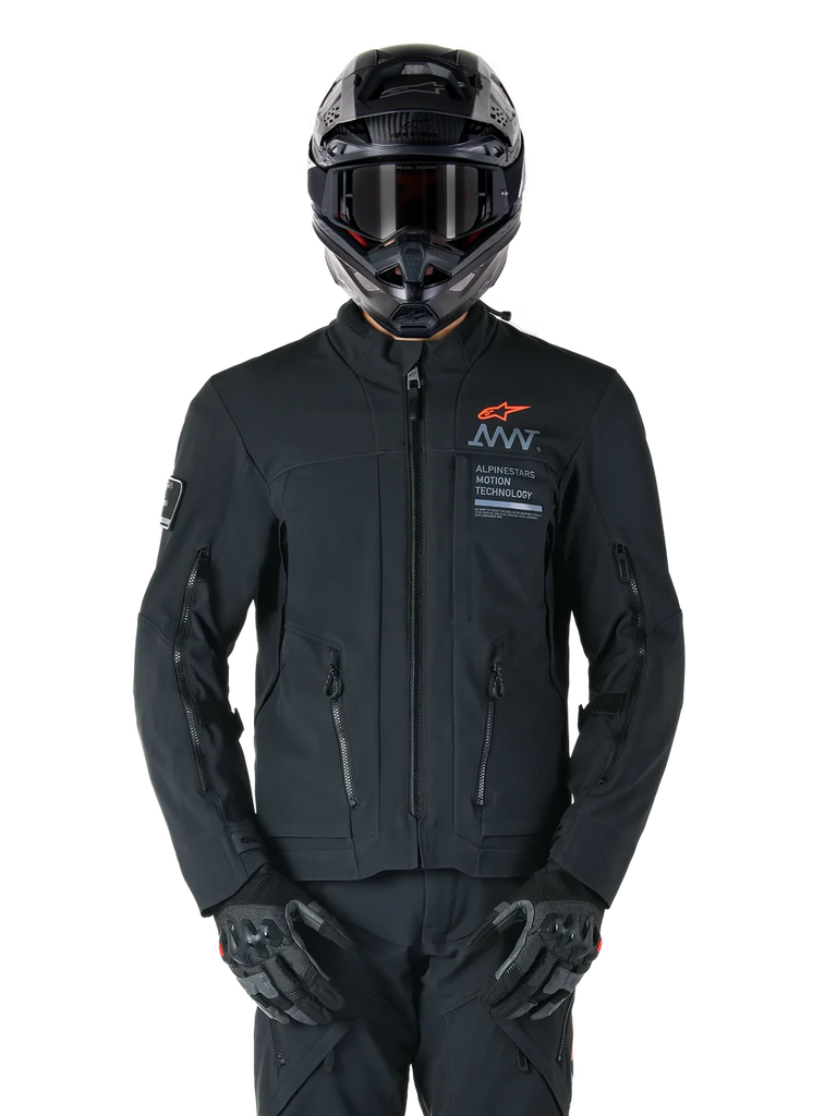 Alpinestars AMT-8 Stretch Drystar® XF Jacket, Black Motorcycle Jacket, featuring orange Alpinestars logo and grey AMT branding, high collar with front zipper and vents, worn with black helmet and gloves, protective adventure touring gear