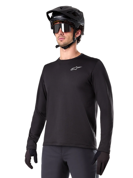 Alpinestars A-Dura Thermal Jersey, Black long-sleeve mountain bike jersey, white chest logo, worn with black helmet and gloves, sleek sporty design for trail riding