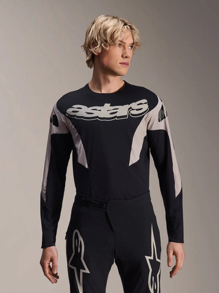Alpinestars A-Supra Melt Jersey Long Sleeve, MTB Mountain Bike Jersey, Black and Gray, featuring 'astars' graphic across the chest and patterned sleeves, worn with matching performance pants