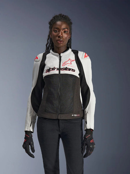 Alpinestars Woman Stella SMX Air Jacket, Ice Gray, Black, and Coral Fluo, featuring mesh construction and perforated panels, worn by a female model with black motorcycle gloves and pants, front view.