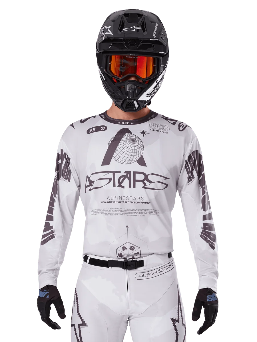 Alpinestars 2025 Racer Hollow Jersey, Motocross Jersey, White and Black, worn with matching white MX pants and a black helmet with orange goggles, featuring bold Alpinestars branding and globe graphics, professional off-road racing gear