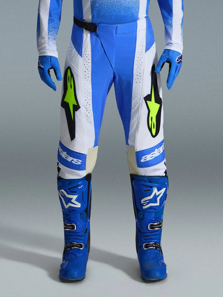 Alpinestars 2026 Techstar Knif Pants, Motocross Pants, Ucla Blue, Black, and Yellow Fluo, worn with matching blue gloves and boots, featuring white panels and vibrant yellow fluo logos, ergonomic racing fit for off-road performance