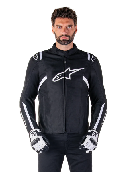 Alpinestars T-SPS V2 Waterproof Jacket in Black and White, front view on model, waterproof textile motorcycle jacket featuring white shoulder and arm stripes, large white Alpinestars logo on chest, worn with protective motorcycle gloves, sleek sport-inspired silhouette
