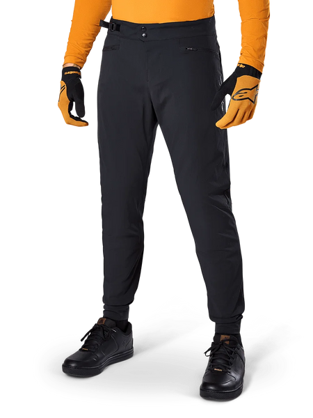 Alpinestars A-Dura Pants, Mountain Bike Pants, Black, side waist cinches and zippered pockets, worn with orange jersey and gloves, sporty regular fit for MTB riding