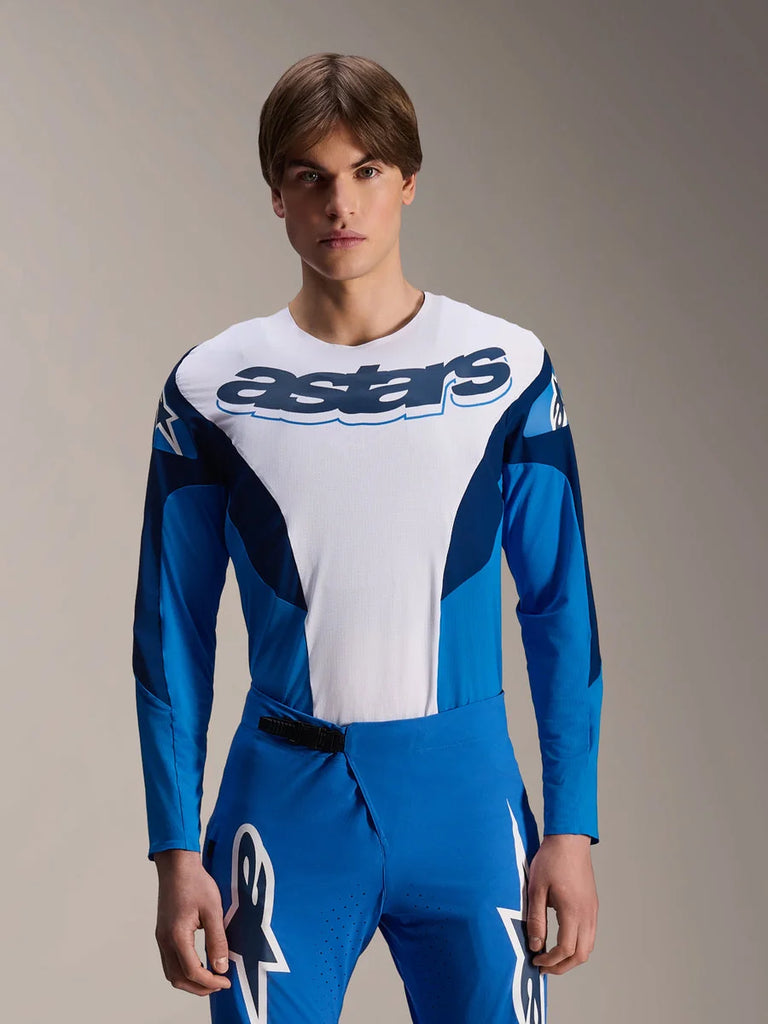 Alpinestars A-Supra Melt Jersey Long Sleeve, Blue and White MTB Jersey, featuring bold astars branding across the chest, dark blue sleeves, worn with matching blue racing pants with white star logos, performance mountain bike apparel