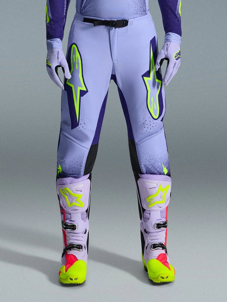 Alpinestars 2026 Supertech Scenz Pants, Motocross Pants, Purple Yellow Fluo, featuring large neon yellow logos on the thighs, worn with matching purple and yellow motocross boots and gloves, athletic-fit performance design for off-road racing