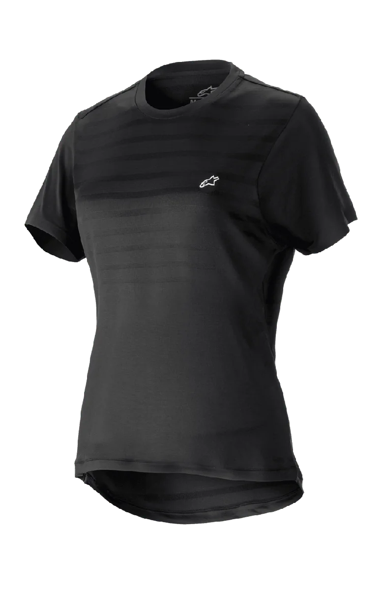 Alpinestars Women Stella Alps Constellation Jersey, Short Sleeve Mountain Bike Jersey, Black with subtle horizontal stripes on chest, small white logo, round neckline, extended tail for coverage, lightweight breathable fabric for MTB