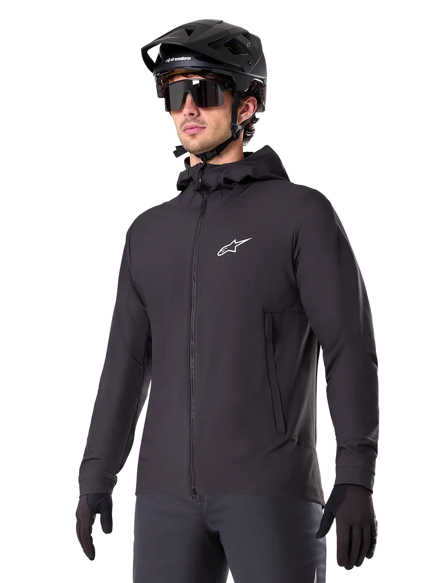 Alpinestars A-Dura Thermal Jacket, Black Cycling Jacket, hooded design with front zipper, white star logo on chest, worn with black mountain bike helmet and gloves, sporty performance gear for cold weather trail riding