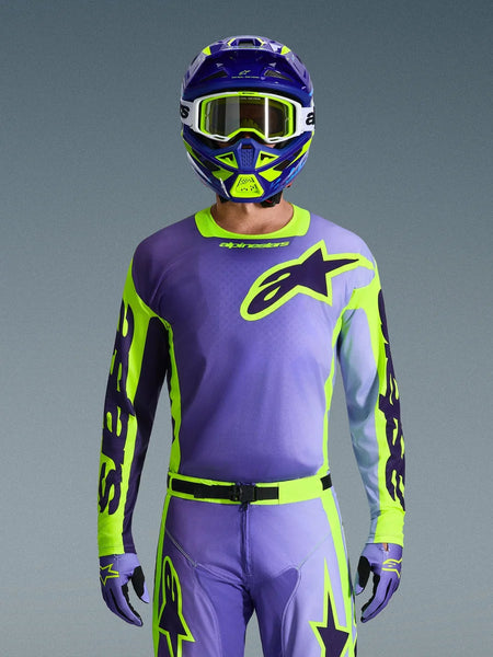 Alpinestars 2026 Racer Portl Jersey, Motocross Jersey, Purple and Yellow Fluo, worn with matching motocross pants, gloves, and helmet, featuring a large Alpinestars star logo on the chest, studio shot against a gray background.