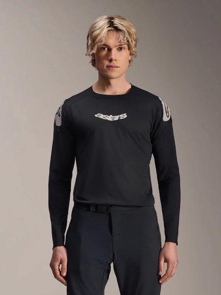 Alpinestars A-Aria Polartec Elite Jersey, Long Sleeve MTB Jersey, Black, featuring white 'astars' chest logo and white shoulder graphics, performance cycling gear worn by a model