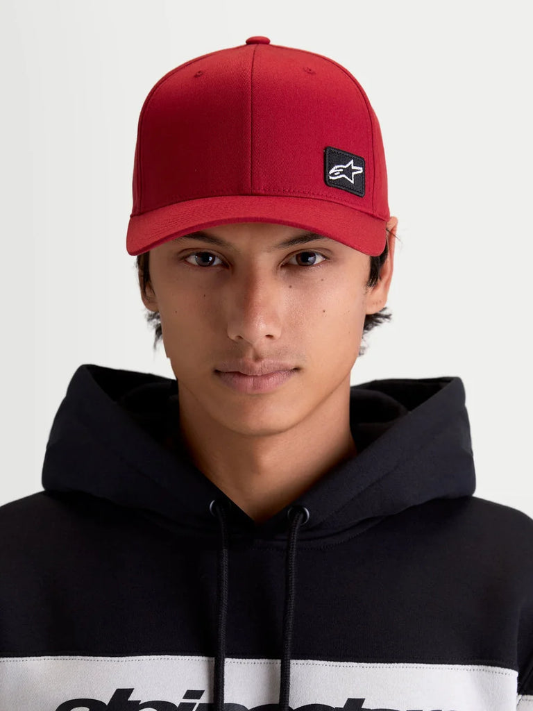 Alpinestars Pivot Hat, Dark Red Sportswear Baseball Cap, Unisex, front view on model featuring the embroidered Astars logo patch, curved bill, structured crown, and durable twill construction.