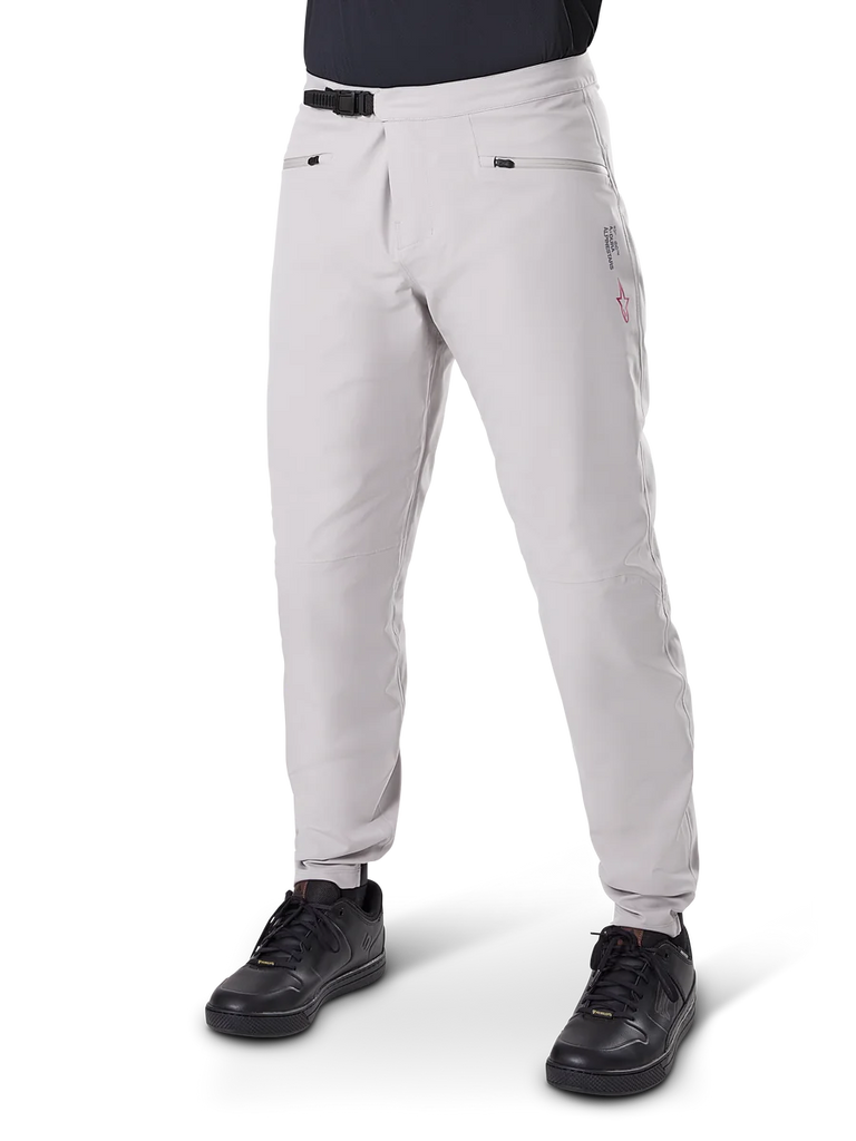 Alpinestars A-Dura Waterproof Pants, Mountain Bike Pants, Titanium Gray, featuring a black ratchet waist closure and zippered hand pockets, tapered legs with elastic cuffs, worn with black shoes, durable 3L waterproof construction for off-road cycling