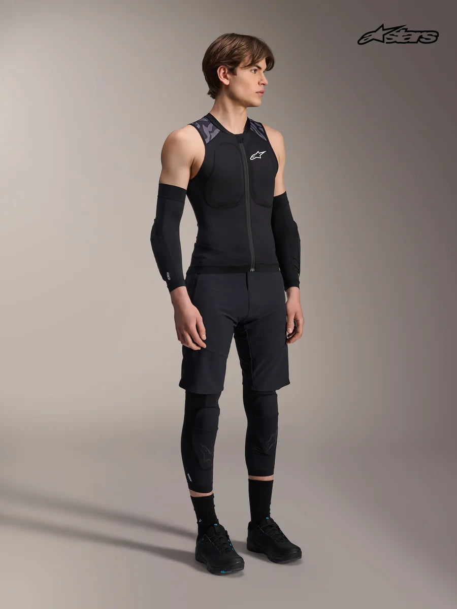 Alpinestars A-Motion Plasma Protection Vest, men's mountain bike protection vest in black camo, on-model studio view wearing protective gear and matching riding apparel, lightweight MTB armor with CE certified chest and back protection