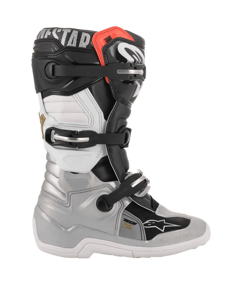 Alpinestars Youth Tech 7S Boots, Motocross Boots, Black Silver White and Gold, side profile view featuring silver lower shell, black and white upper panels, red accent at the top cuff, and three-buckle closure system.
