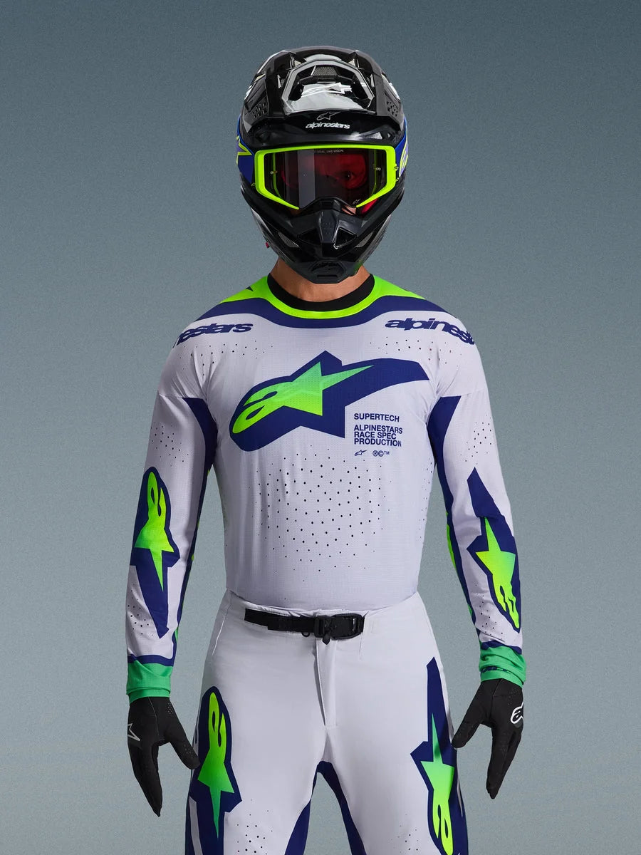 Alpinestars 2026 Supertech Vista Jersey, Motocross Jersey, Light Gray Yellow Fluo and Blue, worn by a rider with matching pants and black helmet, featuring a large chest logo and laser-cut perforations for ventilation, pro-level athletic fit