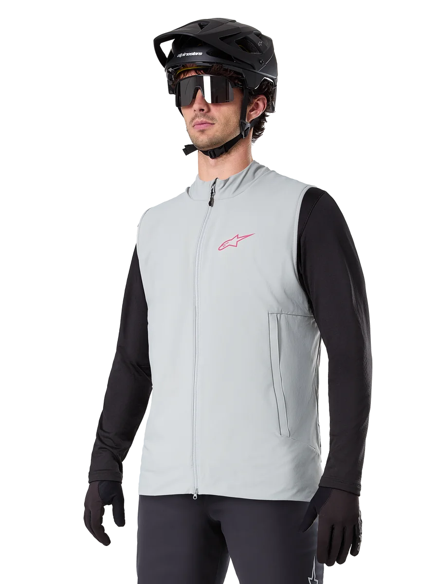 Alpinestars A-Dura Thermal Vest, Titanium Gray, cycling insulated vest, worn over a black long-sleeve shirt with a black mountain bike helmet and gloves, featuring a pink chest logo and vertical zippered side pockets