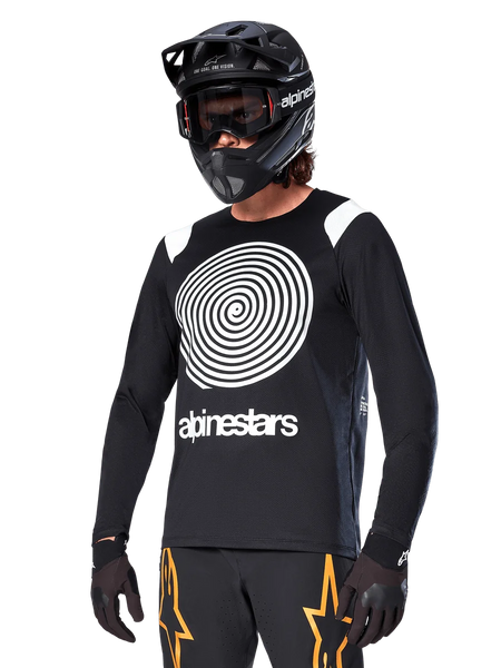Alpinestars A-Supra Oscar Long Sleeve Jersey, MTB Cycling Jersey, Black and White, featuring a bold white spiral design and Alpinestars logo on the chest, worn with a black full-face helmet and goggles, performance mountain biking apparel