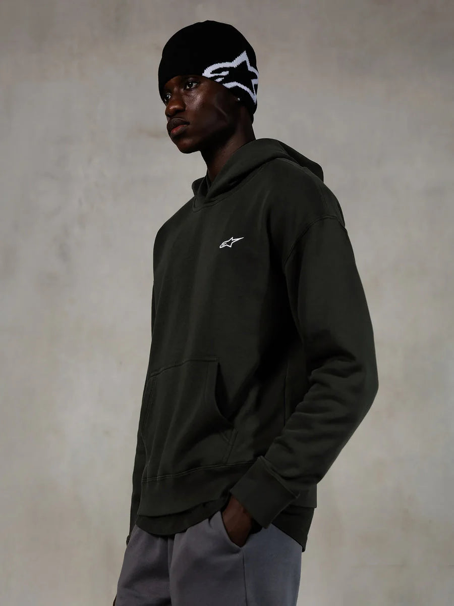 Alpinestars Essentials Ageless Hoodie, Off Black, Male model wearing casual streetwear, dark charcoal stone-washed fleece with a small white star logo, paired with a black Alpinestars beanie and grey pants