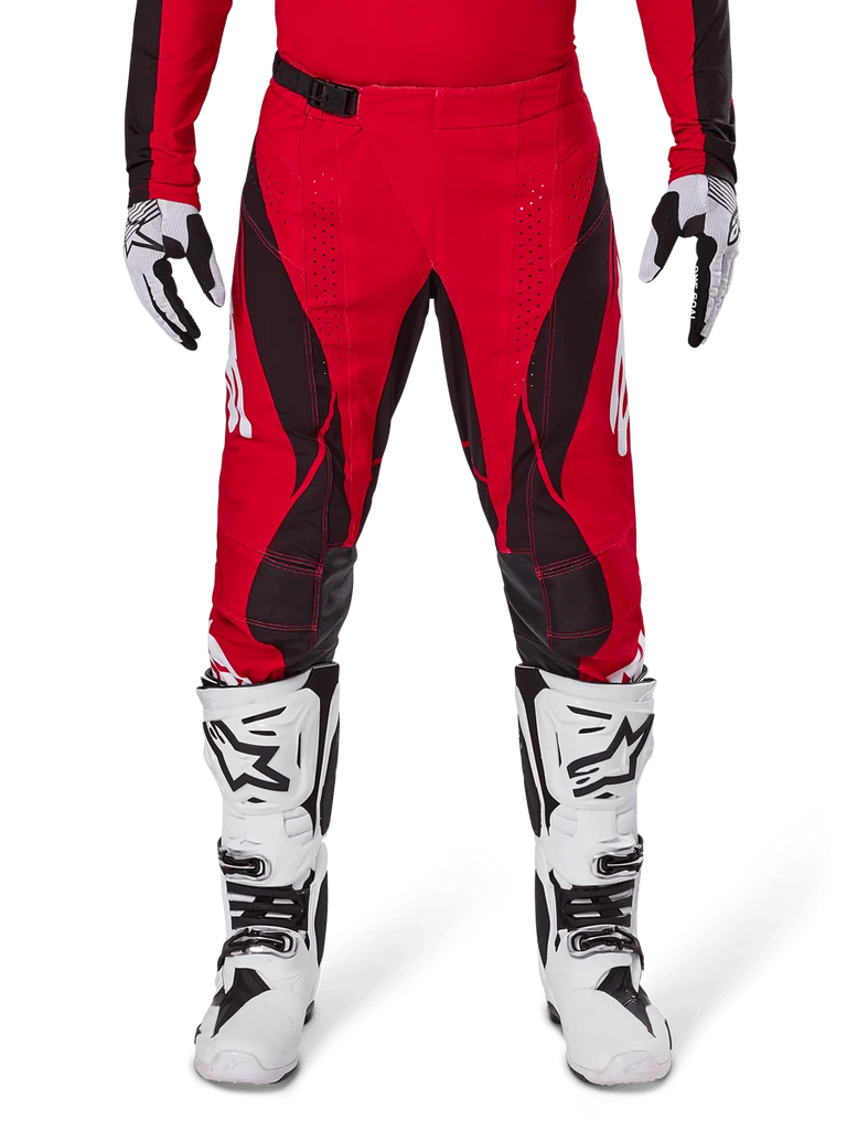 Alpinestars 2025 Techstar Dreem Pants, Motocross Pants, Bright Red and Black, featuring angular patterns and laser-cut ventilation holes, worn with white motocross boots and matching gloves for off-road racing