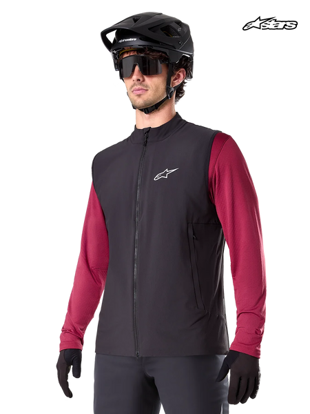 Alpinestars A-Dura Thermal Vest, men's mountain biking thermal vest in black, worn by a model with a helmet and a red long-sleeve jersey, insulation for cold-weather MTB riding