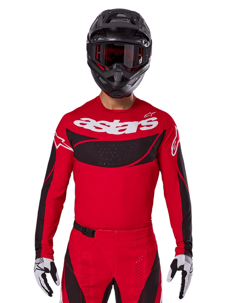 Alpinestars 2025 Techstar Dreem Jersey, Motocross Gear, Bright Red and Black, featuring a white 'astars' logo and black ventilated chest panel, worn with matching pants, black helmet, and white and black gloves, designed for professional off-road racing