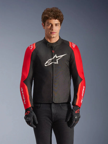 Alpinestars T-SPS V2 Waterproof Jacket, textile motorcycle jacket, Black and Red, worn by a male model with matching black gloves, featuring a large white logo on the chest and white branding on red sleeves, sporty silhouette for all-weather road riding