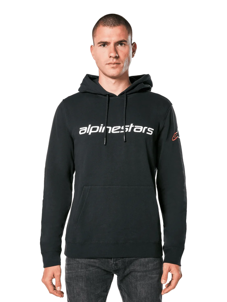 Alpinestars Linear Wordmark V3 Hoodie, Black Pullover Hoodie, White Alpinestars wordmark on chest, Red Ageless sleeve logo, front kangaroo pocket, drawstring hood, worn by a male model, casual motorsport-inspired streetwear