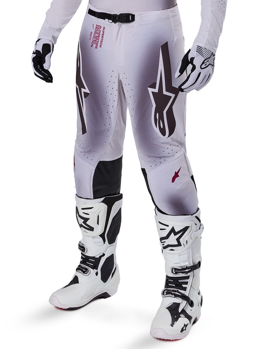 Alpinestars 2025 Supertech Maker Pants, Motocross Racing Pants, Silver and Black, featuring large star logos and red lettering, shown with matching white boots and gloves