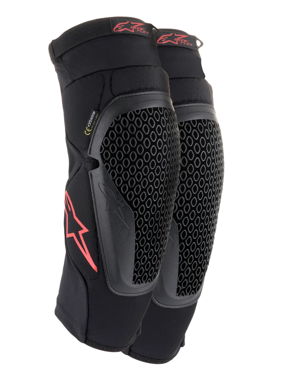 Alpinestars Bionic Flex Knee Protectors, Black and Red, pair of motocross knee guards featuring perforated Nucleon Flex Technology shields, red Astars logos, and elasticated straps on a breathable black mesh sleeve.