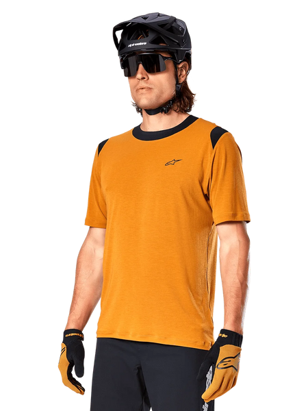 Alpinestars A-Dura Dri Wool Jersey - Short Sleeve, MTB cycling jersey, Dark Gold with black accents, short-sleeve technical wool blend shirt with black shoulder panels, worn with black mountain bike helmet and matching gloves