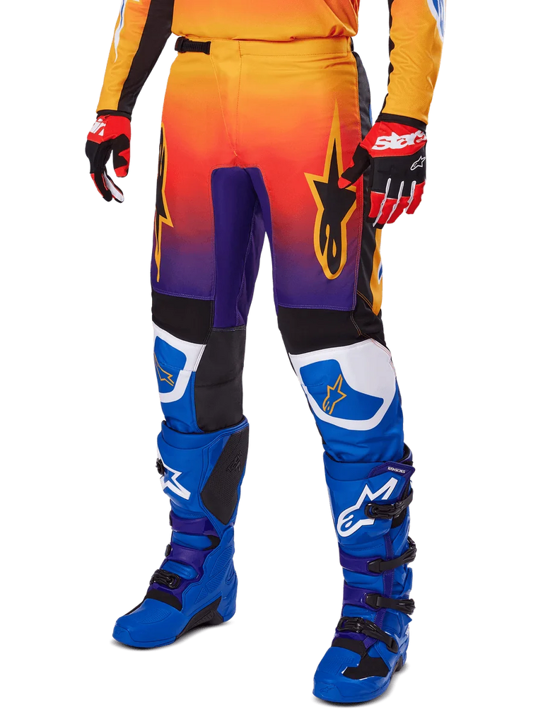 Alpinestars 2025 Fluid Wurx Pants, Motocross Pants, Multicolor orange red and purple gradient with black and blue panels, worn with blue boots and red gloves, featuring star logo graphics and white knee accents, durable performance gear for off-road racing