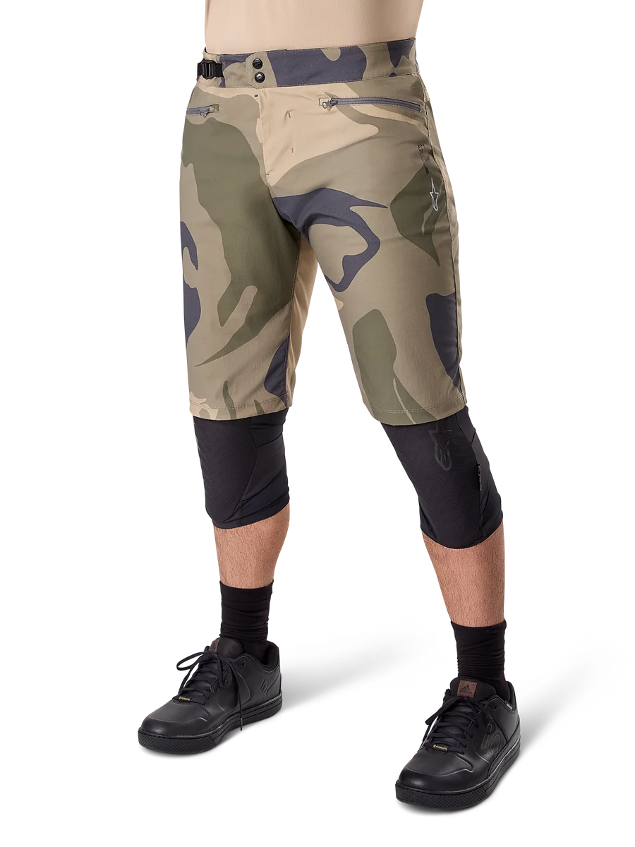 Alpinestars A-Dura Camo Liner Short, Mountain Bike Shorts, Brown Camo pattern, front view showing zippered pockets and side waist adjusters, worn with black knee pads and black cycling shoes, durable gear for MTB