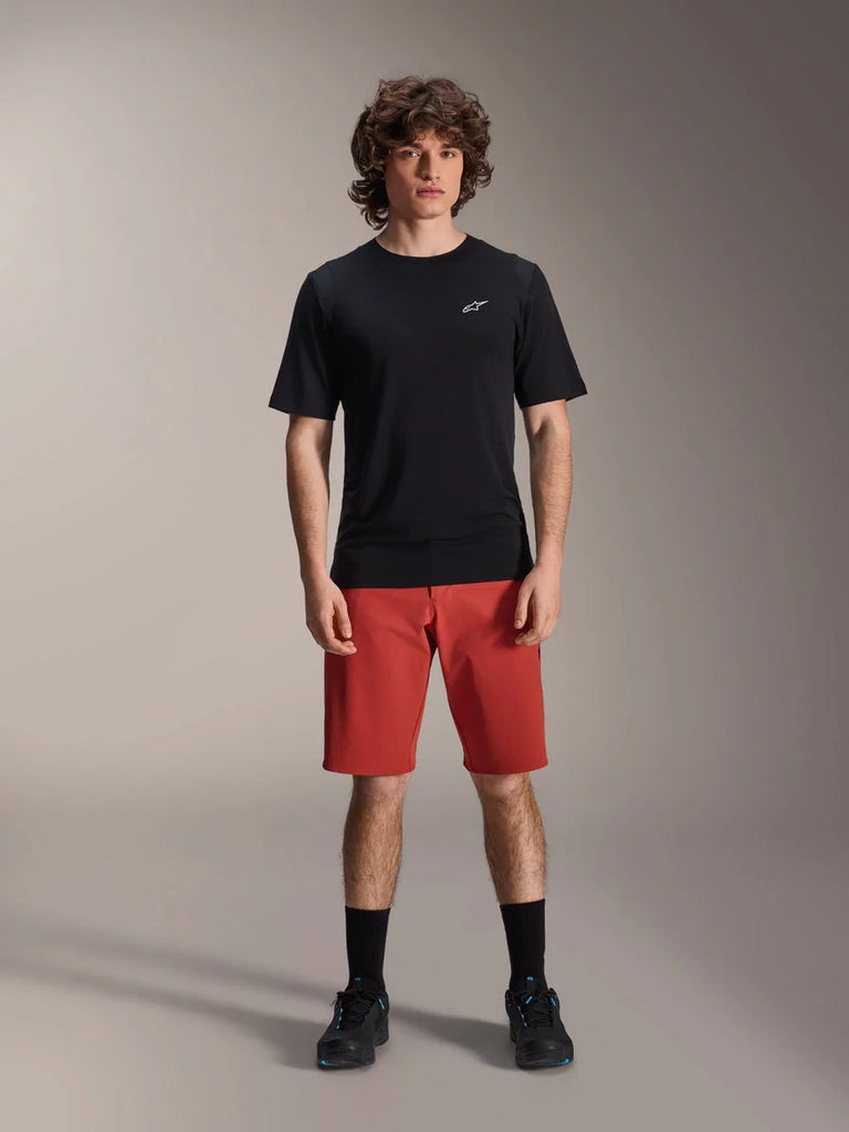Alpinestars A-Dura Elite Shorts, MTB Mountain Biking Shorts, Dark Orange, worn with a black short-sleeved jersey and cycling shoes, performance cycling apparel for mountain biking