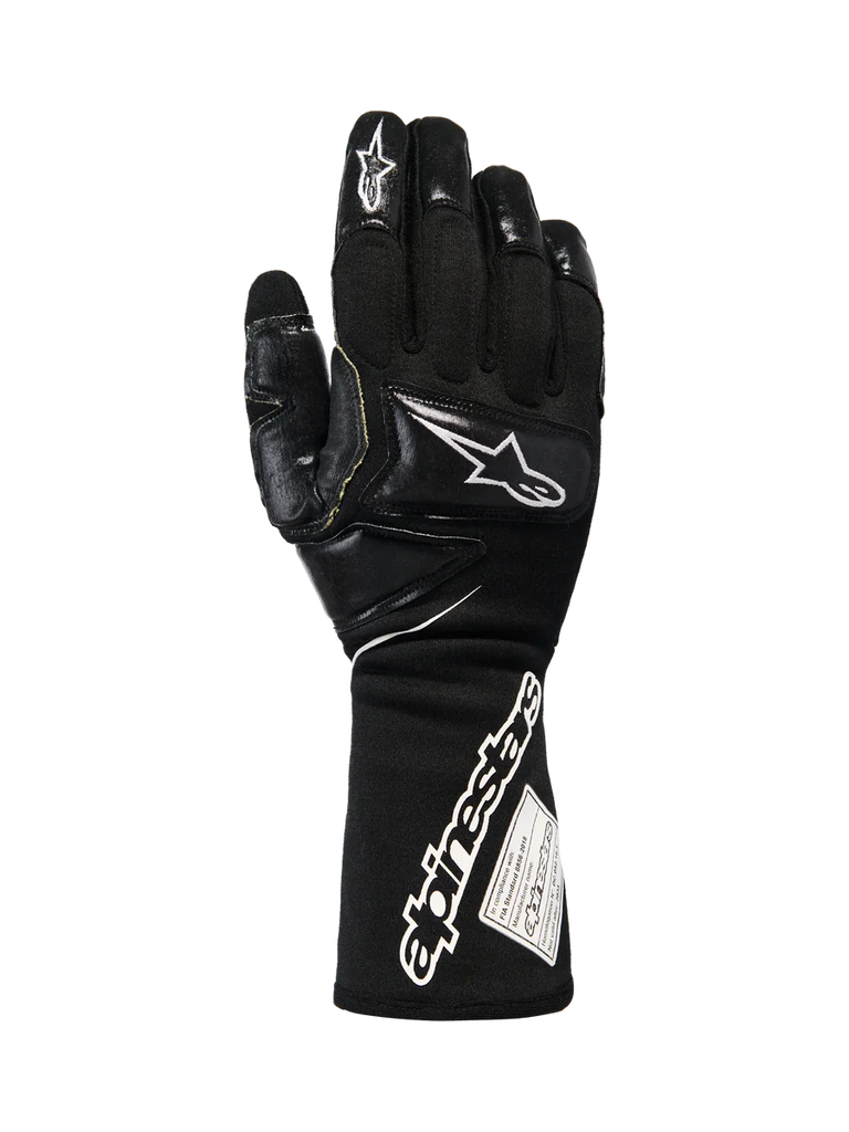 Alpinestars Tech-M V2 Gloves FIA, Black and White Pit-Crew Racing Gloves, featuring an extended cuff with bold Alpinestars branding and FIA certification tag, reinforced knuckle and finger patches for impact protection, professional motorsport gear