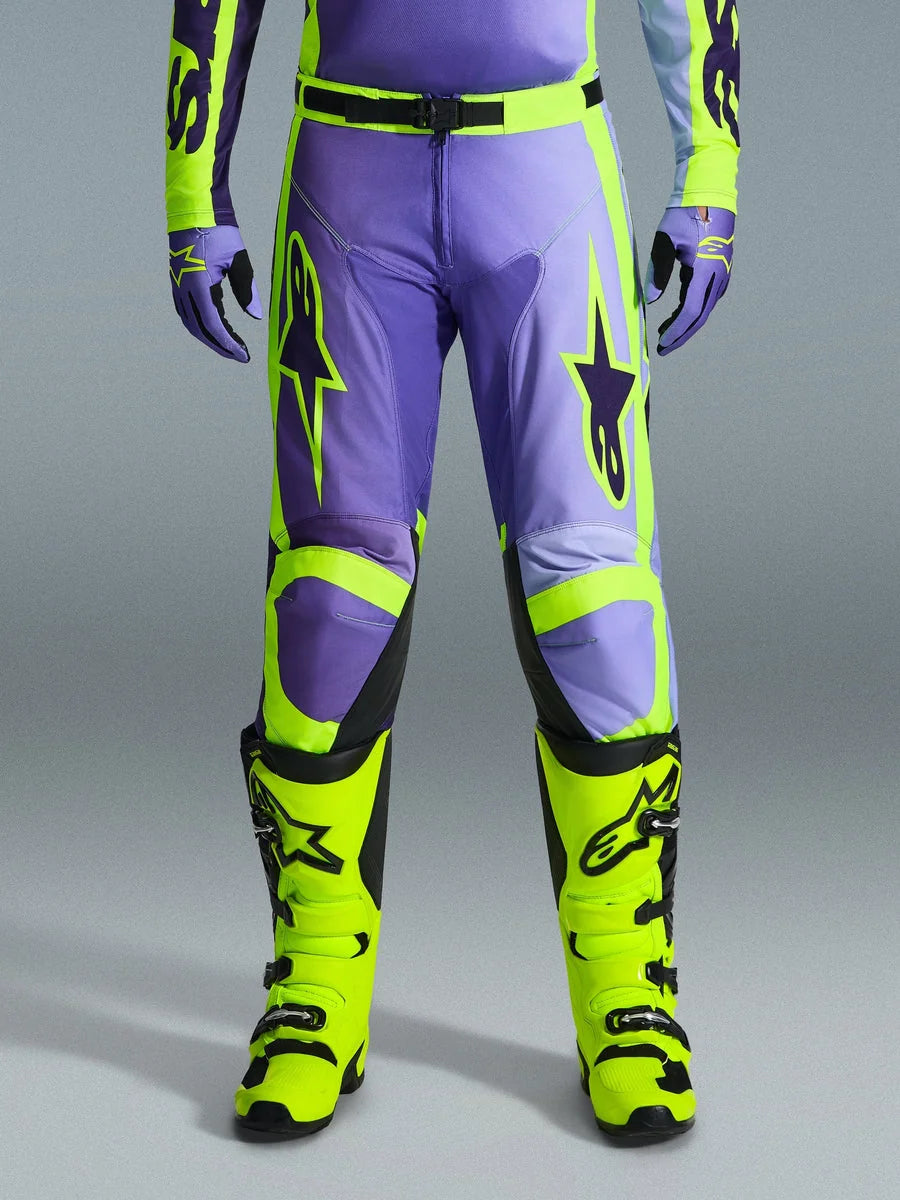 Alpinestars 2026 Racer Portl Pants, Motocross Pants, Purple and Yellow Fluo, worn with matching fluo yellow boots and purple gloves, featuring large star logos and durable polyfabric construction for off-road racing