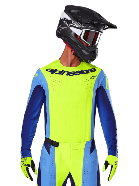 2025 Techstar Melt Jersey, Motocross Racing Jersey, Yellow Fluo and Blue, featuring laser-cut ventilation and athletic race fit, worn by a rider with a black helmet and yellow fluo gloves