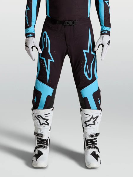 Alpinestars Supertech Vesta Pants, pro motocross racing gear, Black and Turquoise with large star graphics and leather knee panels.