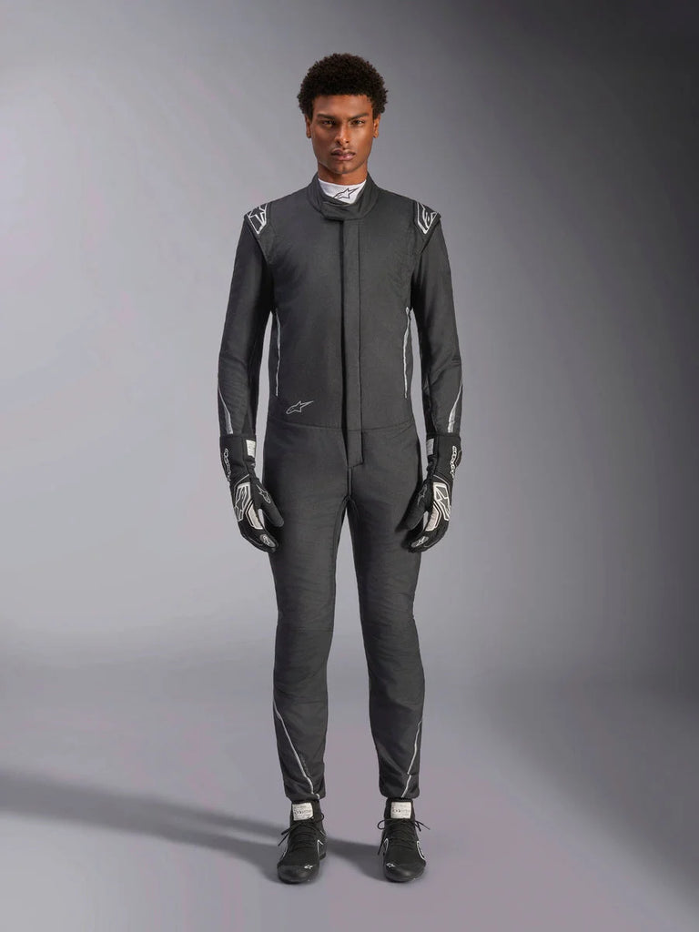 Alpinestars Hypertech V3 Suit, professional auto racing suit, Black and Dark Shadow, worn by a model with matching racing gloves and shoes, slim athletic fit with silver accents and branding, performance motorsport gear