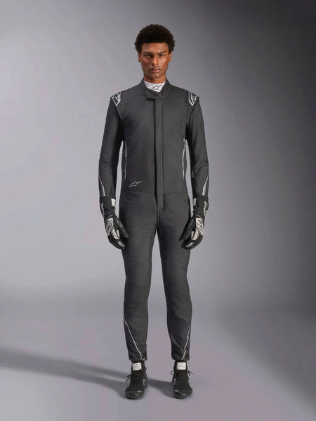 Alpinestars Hypertech V3 Suit, professional auto racing suit, Black and Dark Shadow, worn by a model with matching racing gloves and shoes, slim athletic fit with silver accents and branding, performance motorsport gear