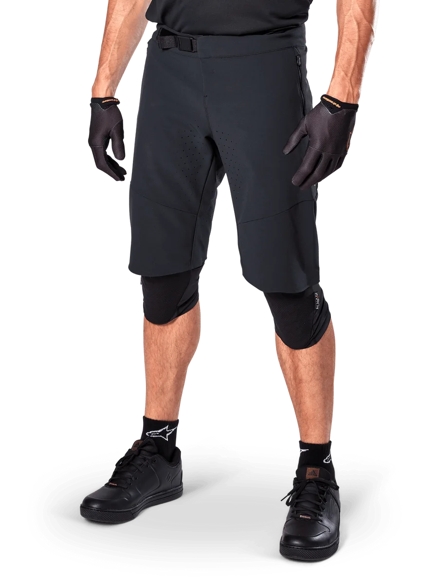 Alpinestars A-Aria Elite Shorts, Black Cycling Shorts, worn with matching black gloves and knee guards, featuring a magnetic buckle and laser-cut perforations, sleek design for off-road mountain biking