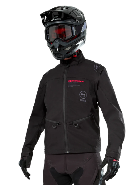 Alpinestars Lite-Dura Softshell Jacket, Black off-road motorcycle jacket with red branding and AS logo, worn with a black motocross helmet, red goggles, and black gloves, featuring zippered hand pockets and adjustable cuffs, designed for enduro riding.