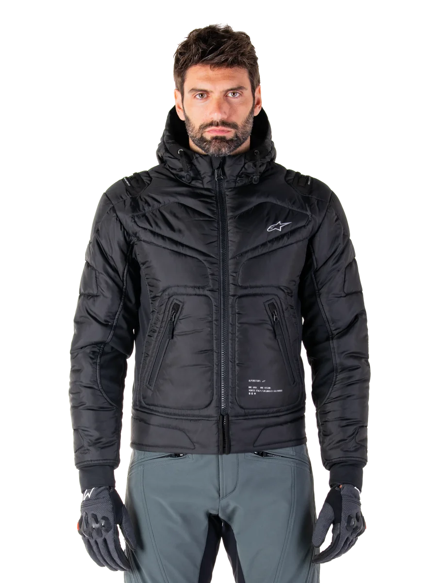 Alpinestars Mohobbs Waterproof Jacket, Black Padded Bomber Motorcycle Jacket, quilted poly fabric with front zipper and zippered pockets, small white logo on chest, worn by a model with grey pants and gloves, urban streetwear design for city riding.