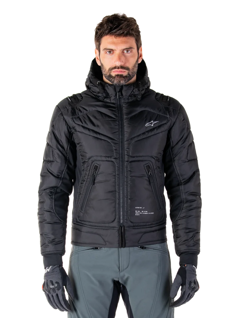Alpinestars Mohobbs Waterproof Jacket, Black Padded Bomber Motorcycle Jacket, quilted poly fabric with front zipper and zippered pockets, small white logo on chest, worn by a model with grey pants and gloves, urban streetwear design for city riding.
