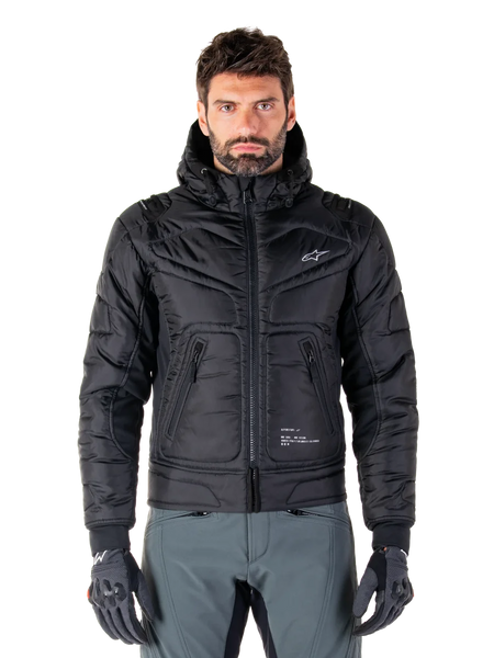 Alpinestars Mohobbs Waterproof Jacket, Black Padded Bomber Motorcycle Jacket, quilted poly fabric with front zipper and zippered pockets, small white logo on chest, worn by a model with grey pants and gloves, urban streetwear design for city riding.