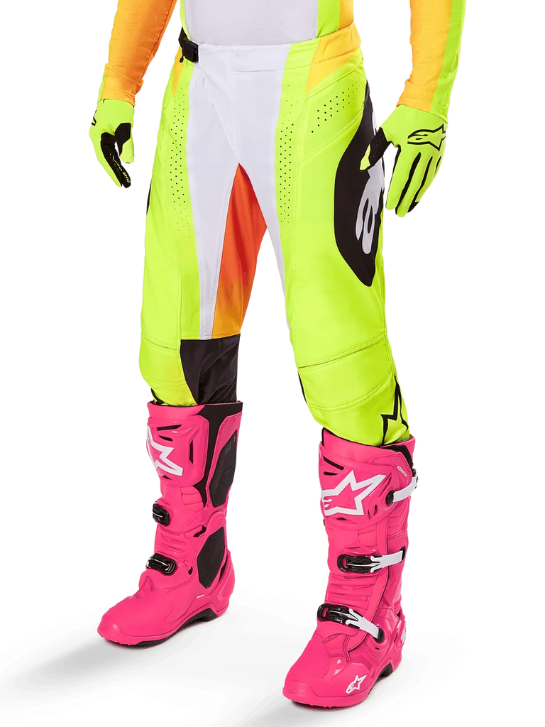 Alpinestars 2025 Techstar Melt Pants, Motocross Pants, Neon Yellow with White and Orange Accents, Black Side Patterns, worn with bright pink motocross boots and neon yellow gloves, featuring perforated ventilation, durable off-road racing gear