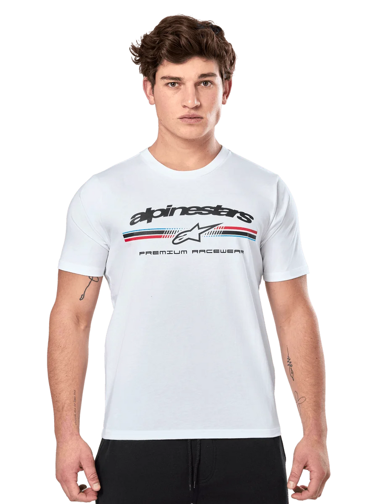 Alpinestars Prevail CSF Tee, White Short Sleeve T-Shirt, featuring a front paddock-style tri-color stripe logo with red and blue accents, black Alpinestars branding, and 'Premium Racewear' text, worn by a male model, casual motorsport apparel